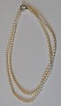 Zweireihige 
Perlenkette, 
Salzwasserperlen, 
20. 
Jahrhundert. 
Mit 
Silberverschluss.
 L.: 38 cm. und 
...