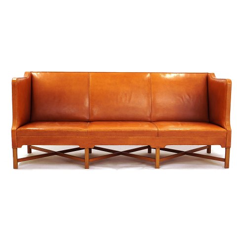 Kaare Klint sofa i patineret naturskind med 
ottebenet krydsstel udført i mahogni. God stand 
uden skader. L: 199cm. H: 82cm. D: 80cm