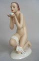 Porzellanfigur 
eines sitzenden 
nackten Frau 
mit Schale, 
kalt bemalt, 
20. 
Jahrhundert. 
...
