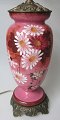 Englisch 
Tischlampe, 19. 
Jahrhundert. 
Rosa Glas 
(Topaz-Glas) 
mit 
Emailleschmuck 
aus Blumen. Fuß 
...