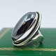 Georg Jensen; 
Stor oval ring 
i sterling sølv 
prydet med 
hæmatit 
(blodsten). 
Dessin nr. 46E. 
...