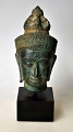 Buddha-Büste 
aus Bronze, 20. 
Jahrhundert. 
Auf einem 
Holzsockel. 
Höhe: 13 cm. Zu 
Fuß: 19 cm.