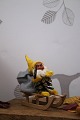 Old gnome on a wooden sled. The gnome is made of pine cones, pipe cleaners, painted face and ...